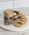 Bio Haferbrot im Glas mit Scheiben aufgeschnitten – praktisches, frisches Brot zum Selberbacken, serviert mit cremigem Dip auf modernem Marmorteller.